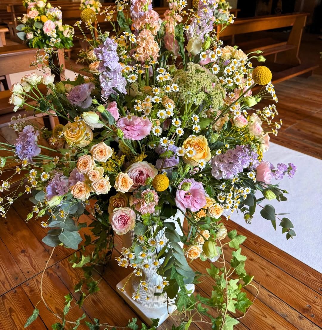 Grande composizione di fiori pastello su un tavolo di legno