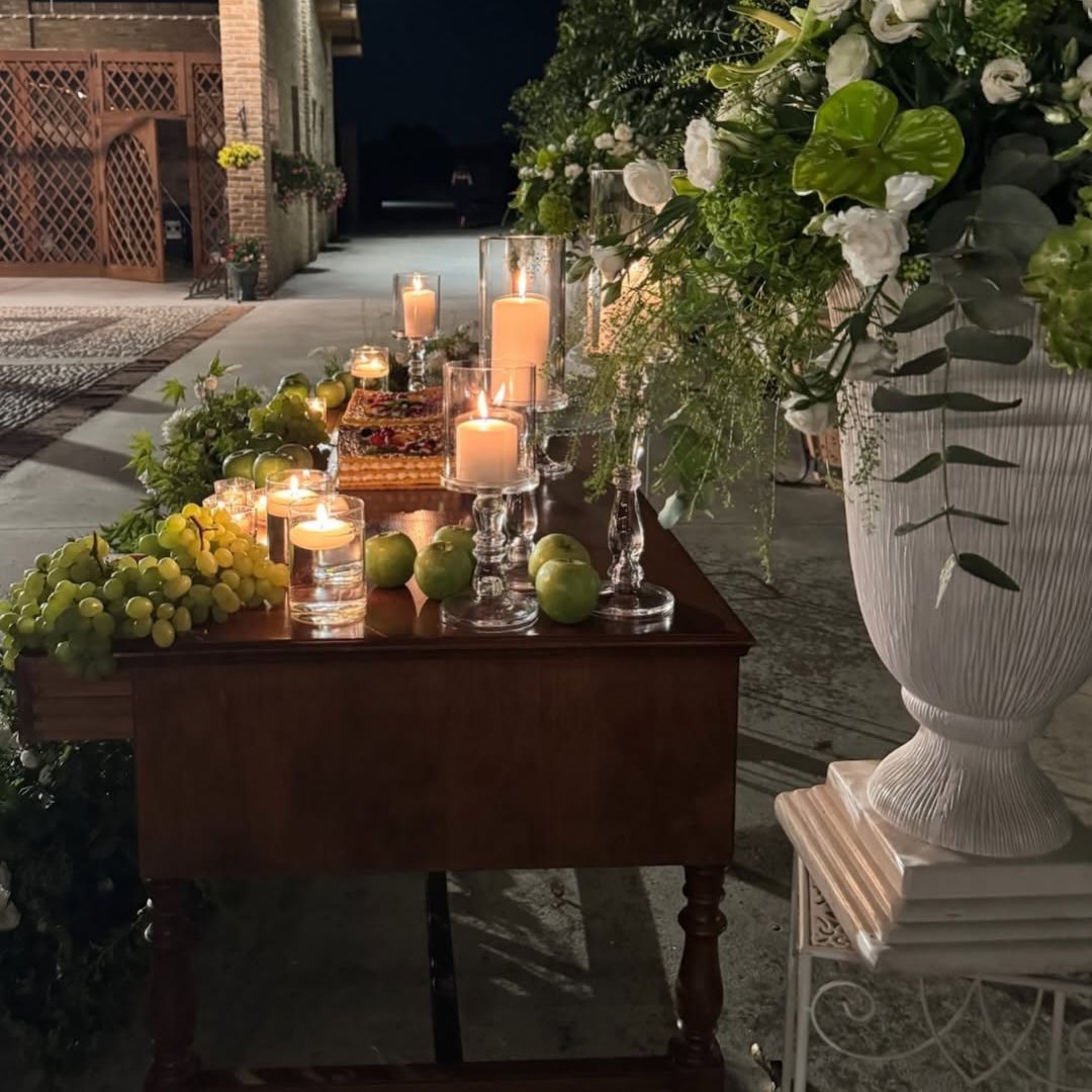 Tavolo del taglio della torta con candele, uva e composizione verde